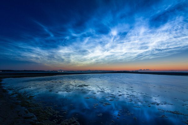Titelbild Blaue Stunde & Nachtfotografie. Es zeigt Leuchtende Nachtwolken über der Kieler Förde
