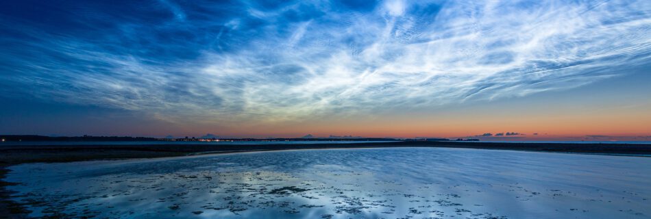 Titelbild Blaue Stunde & Nachtfotografie. Es zeigt Leuchtende Nachtwolken über der Kieler Förde