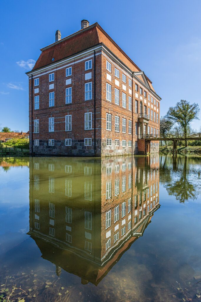 Das Barocke Gutshaus von Ludwigsburg in Schleswig-Holstein spiegelt sich im Burggraben