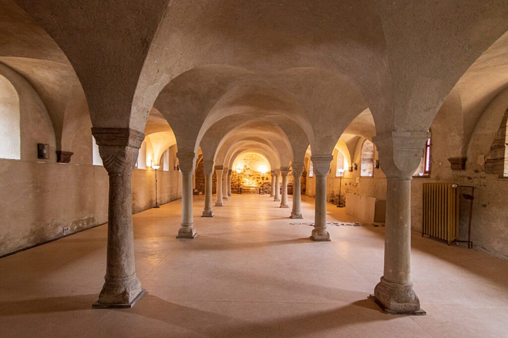 Ein Raum im Kloster Ilsenburg mit einer beeindruckenden doppelten Säulenreihe und kunstvoll gestalteten Deckengewölben. Die Architektur strahlt historische Eleganz aus und vermittelt eine spirituelle Atmosphäre.