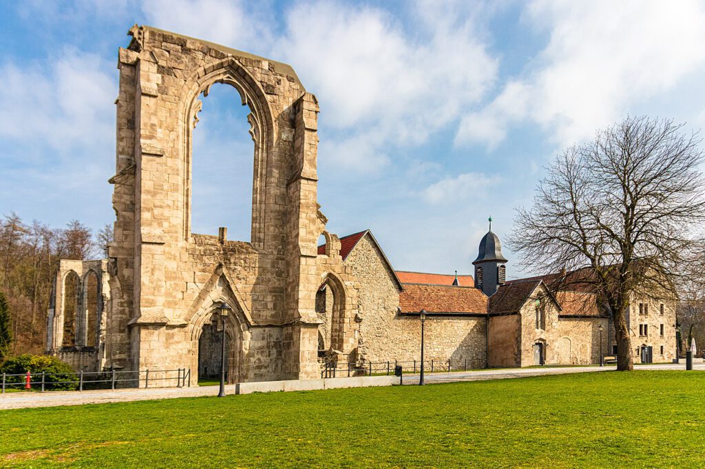 Außenaufnahme des Klosters Walkenried: Links die imposante Ruine der ehemaligen Klosterkirche, rechts der gut erhaltene Teil der Anlage mit dem Kreuzgang. Die Szene zeigt den Kontrast zwischen Verfall und Erhalt in der historischen Klosterarchitektur