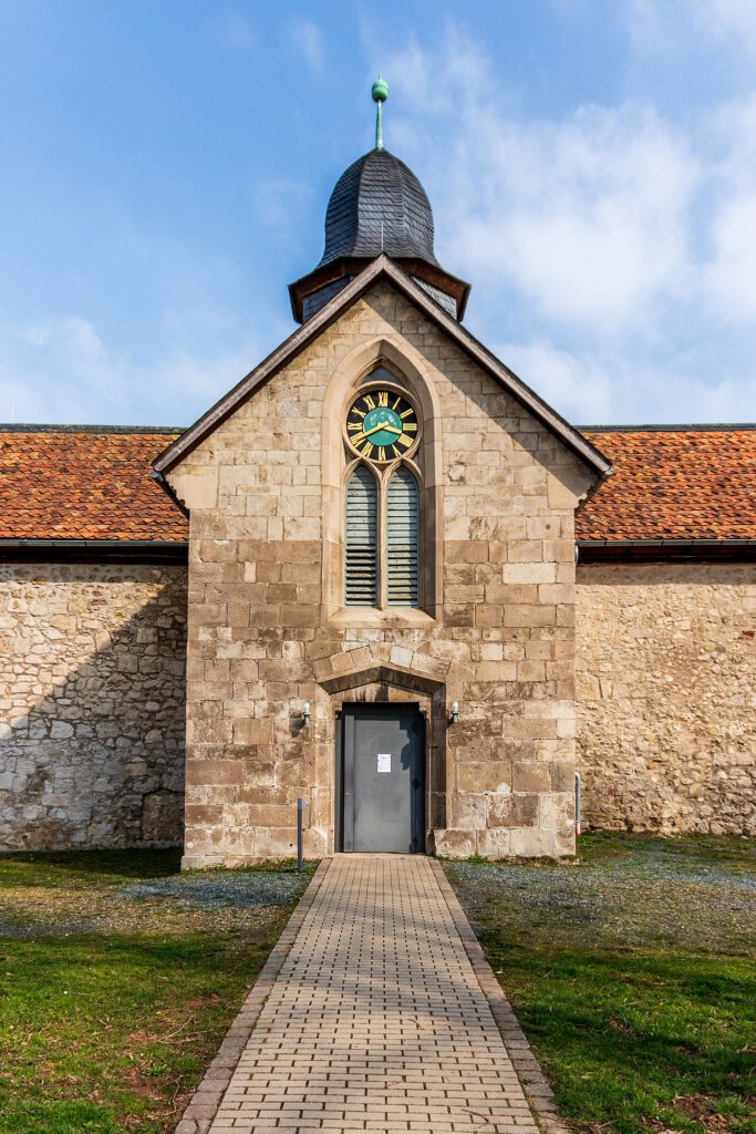 Der Innenhof des Klosters Walkenried mit dem Kreuzgang, einem historischen Gebäude mit Giebel und einer Uhr. Die Architektur vermittelt den Charme der Klosteranlage und bietet Einblicke in das mittelalterliche Erbe.